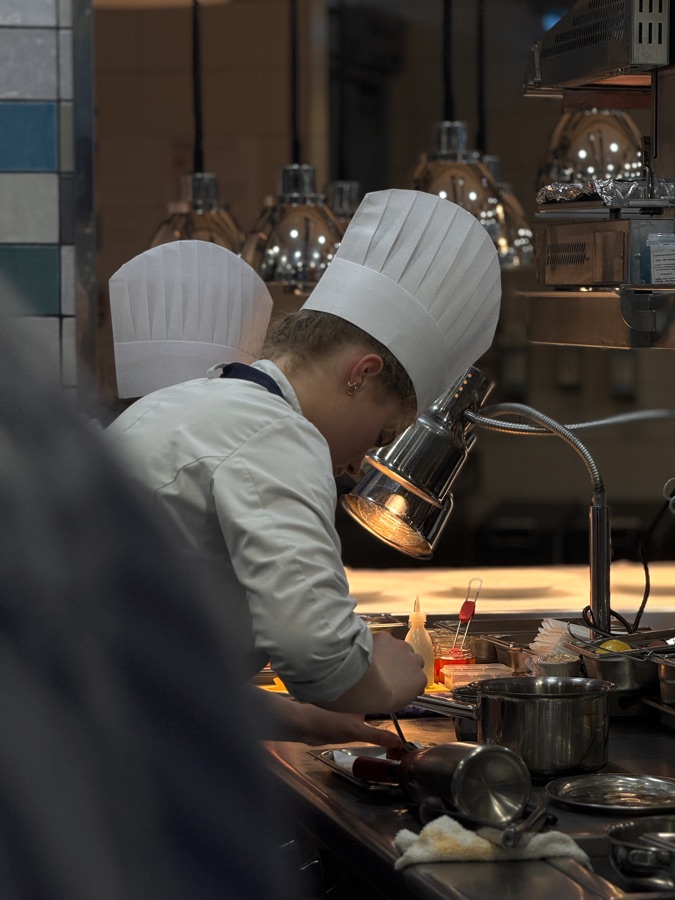 Chef plating a course at the pass in the kitchen of Restaurant Lakeside, Hotel The Fontenay