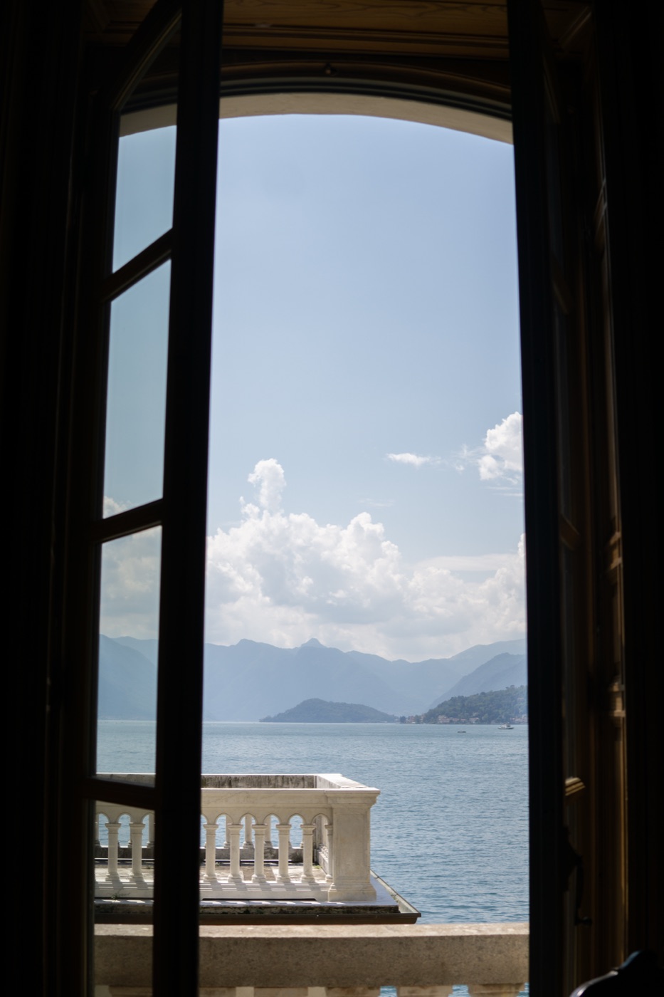 View through an open window onto the lake and the mountains