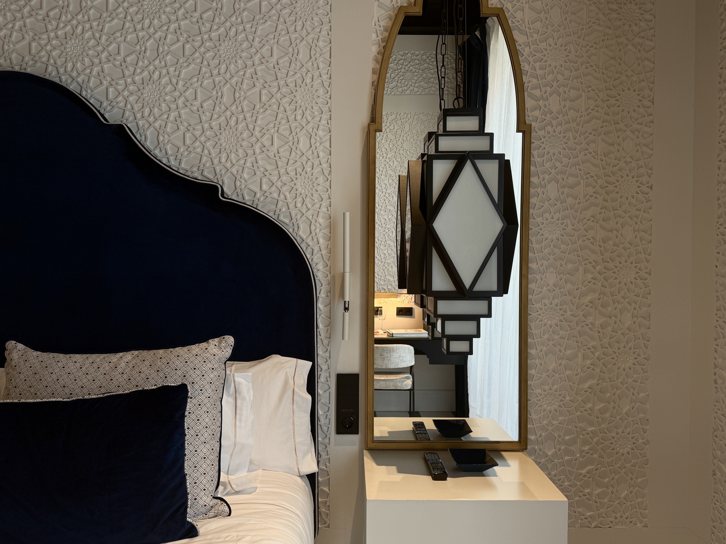 Hotel room with a dark blue headboard and an art deco mirror at Hotel Palacio Don Ramón, Sevilla