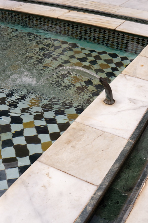 Mosaic tiled pool edge in green, white and gold